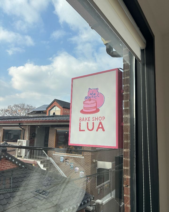 창문에 붙어있는 베이크샵루아의 귀여운 고양이 캐릭터 로고