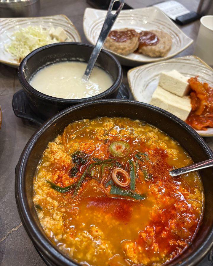 순두부 찌개와 떡갈비, 두부김치 등 다채로운 곁들임이 함께 제공됩니다.