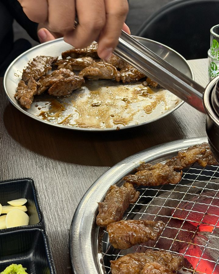 맛있게 구워진 고기를 개인 접시에 담아주는 모습
