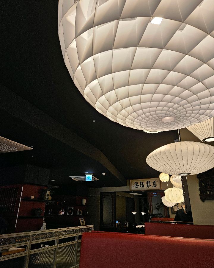 천장에 달린 독특한 디자인의 조명이 은은하게 빛나며 고급스러운 분위기를 연출하는 모습