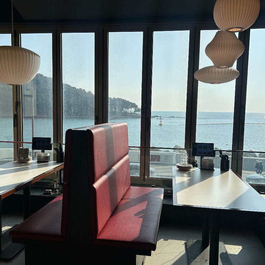 테이블에 앉아 넓은 창밖으로 해운대 바다를 바라볼 수 있는 멋진 뷰
