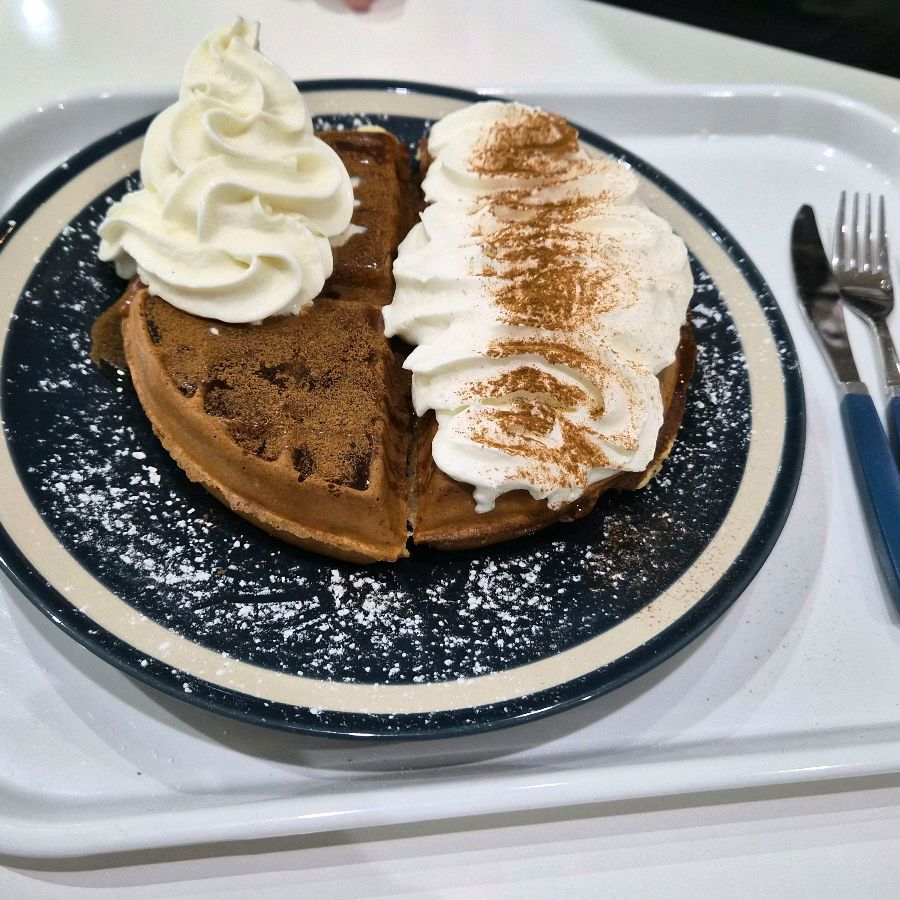 나이프와 포크가 놓인 접시 위에 올려진 와플