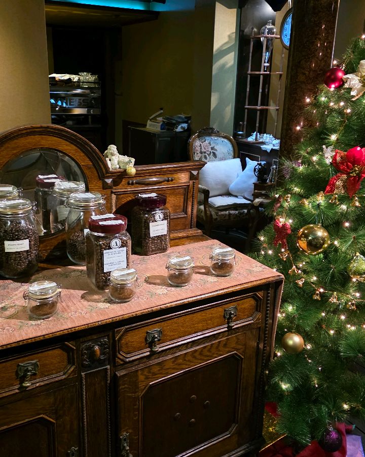 앤티크 가구 위에 놓인 다양한 원두 병들과 크리스마스 트리 장식