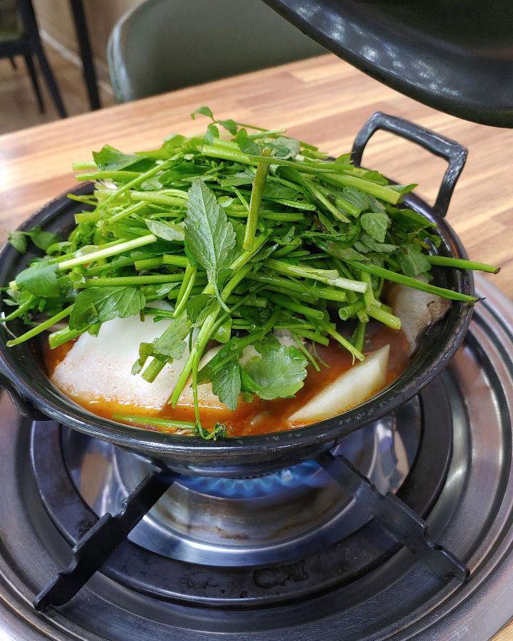 냄비 가득 담긴 신선한 미나리, 등촌샤브칼국수의 핵심 재료이다.