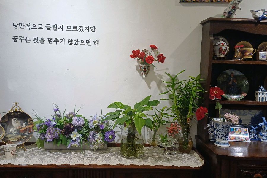 벽면에 걸린 아름다운 그림과 꽃 장식이 인상적인 인테리어