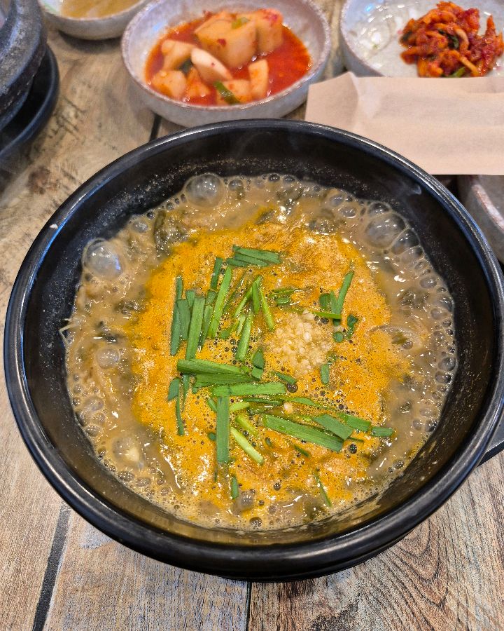 싱싱한 부추와 다진 마늘이 올려진 추어탕