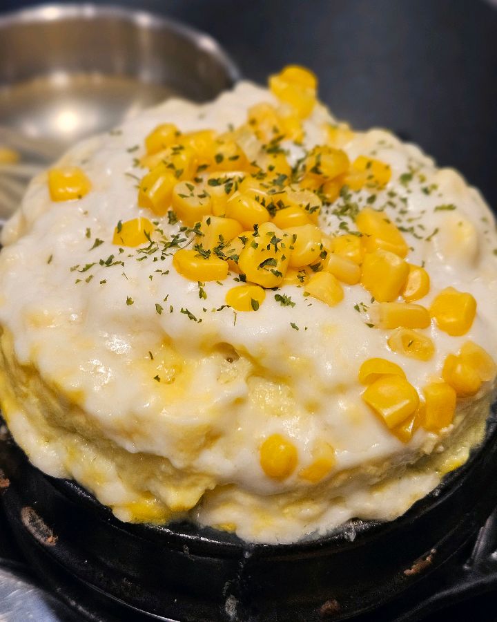 화산처럼 봉긋 솟아오른 폭탄 계란찜 위에 옥수수 알갱이가 뿌려져 있는 모습