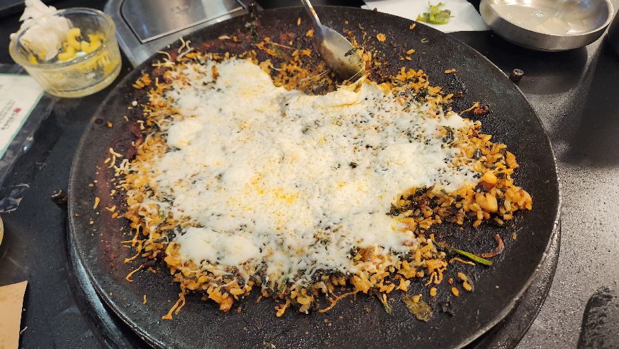 쭈꾸미 양념에 볶아진 밥 위에 김가루가 뿌려져 있는 모습