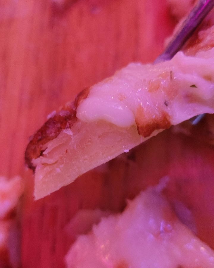 페스츄리 피자 단면을 확대한 사진, 덜 익은 듯한 도우의 질감이 보인다.