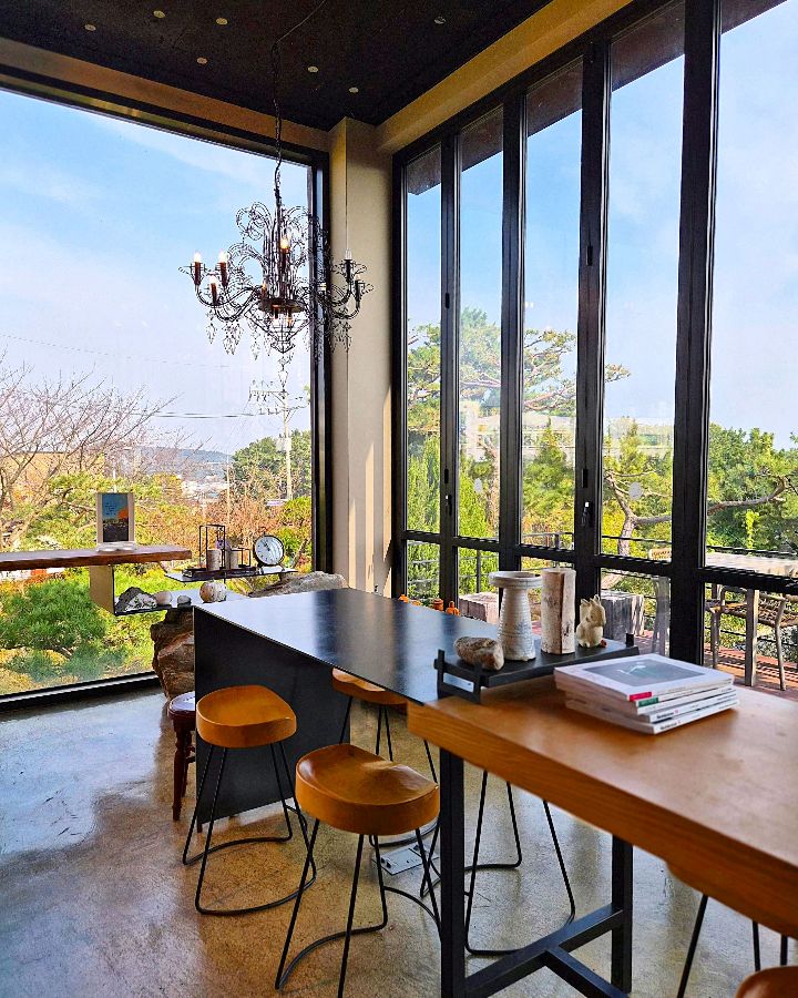 카페 내부에서 바라본 풍경, 넓은 창을 통해 아름다운 자연을 감상할 수 있다.