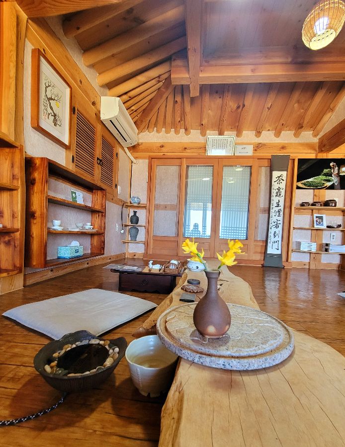 따뜻한 햇살이 쏟아지는 매월당 내부, 은은한 조명과 나무 테이블이 아늑함을 더한다.