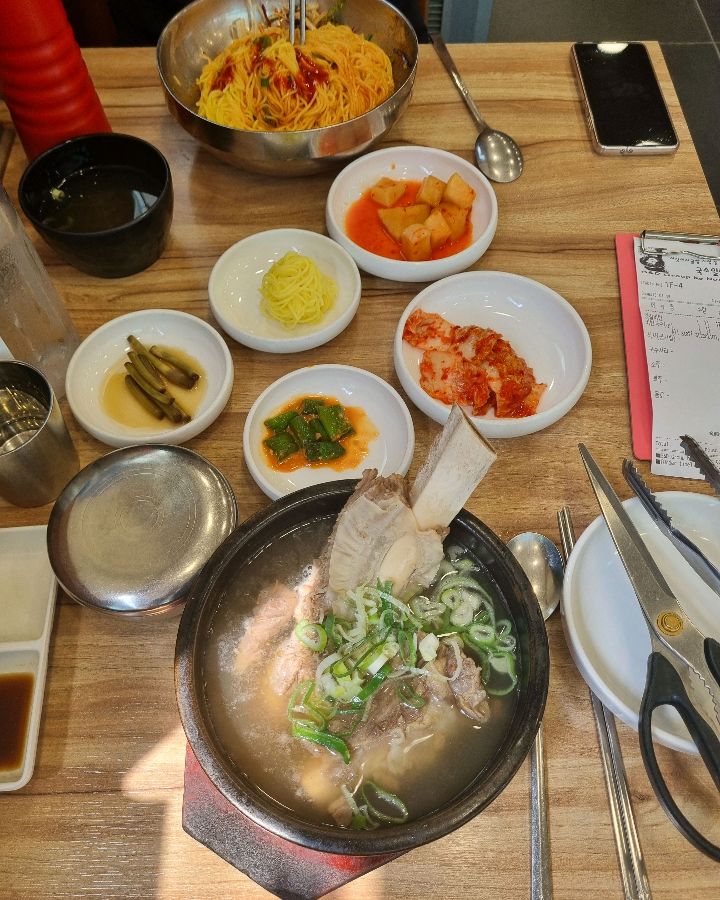 갈비탕과 회국수, 그리고 다양한 반찬들이 한 상 가득 차려진 모습.