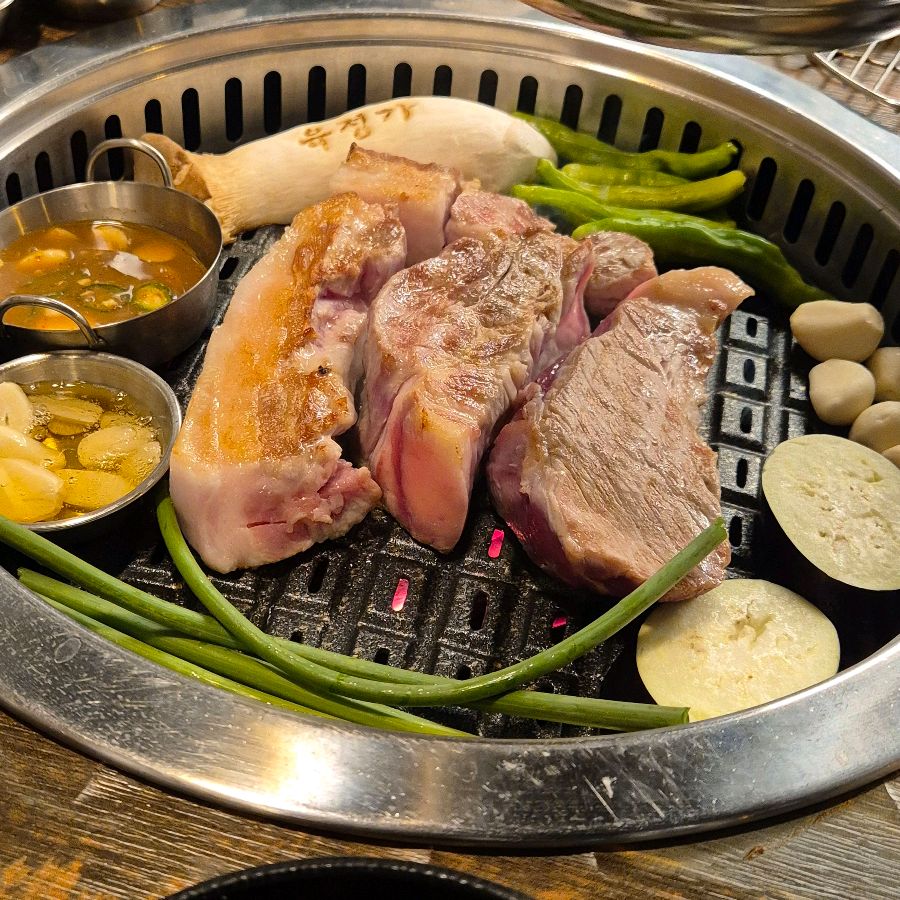 육정가의 불판 위에서 익어가는 꽃목살과 통삼겹