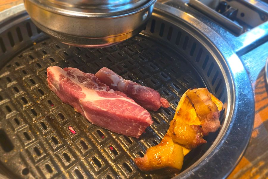 숯불 위에서 노릇하게 익어가는 육정가의 통삼겹살