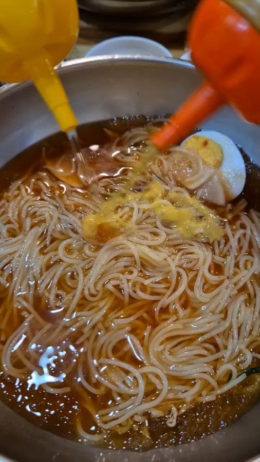 밀면에 식초와 겨자를 뿌리는 모습