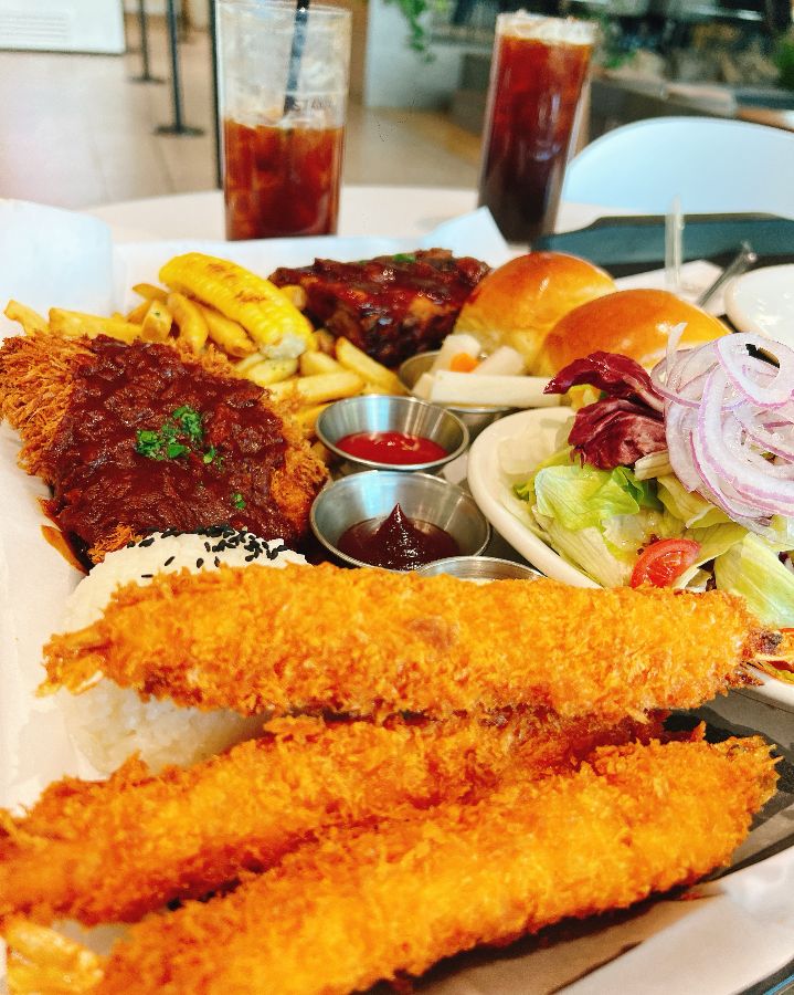 수제 돈까스, 왕새우튀김, 샐러드, 빵, 음료가 함께 제공되는 플래터
