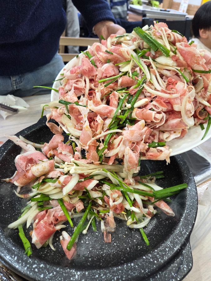 불판 위에 푸짐하게 올려진 오리불고기