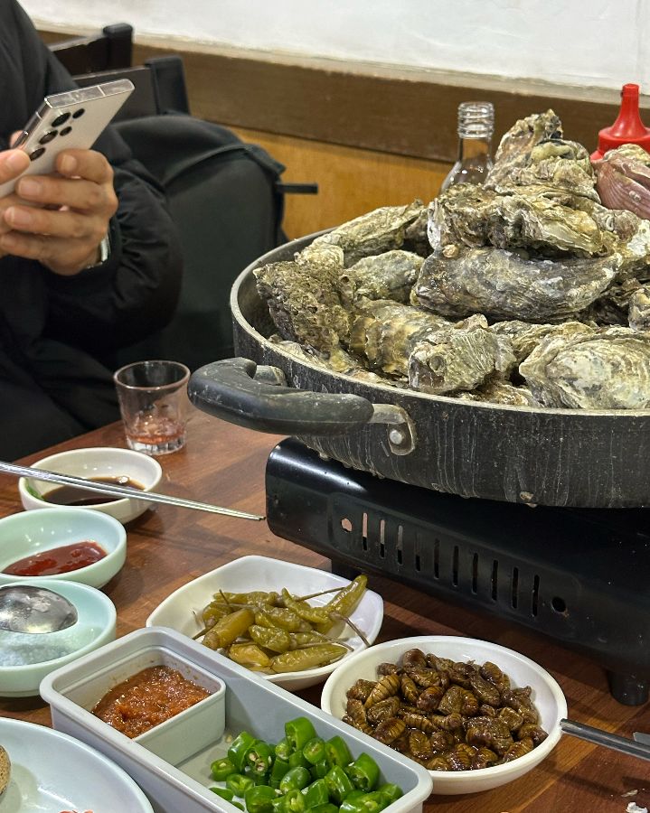 굴구이 냄비와 다양한 곁들임 메뉴