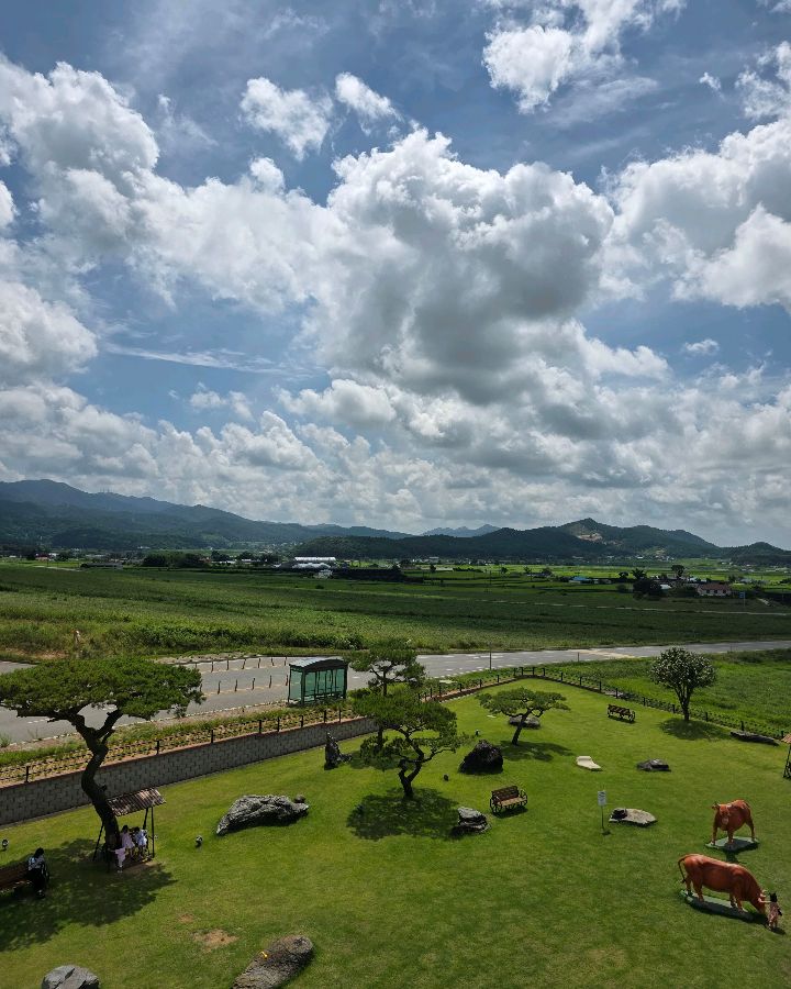 카페에서 내려다본 넓은 초원과 조형물, 탁 트인 하늘