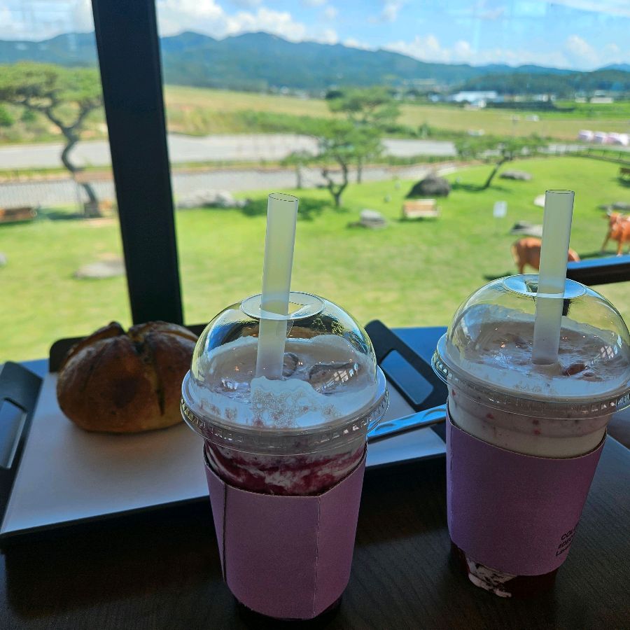 딸기 라떼 두 잔과 빵이 함께 놓여있는 모습