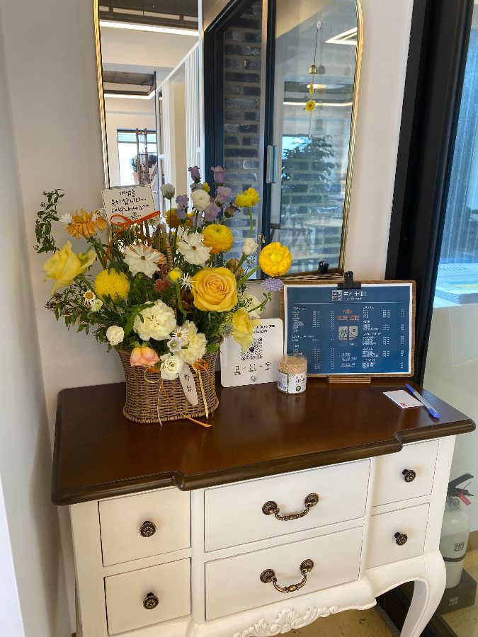 카페 입구에 놓인 메뉴판과 꽃 장식.