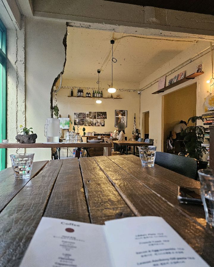 따뜻한 햇살이 들어오는 창가 좌석과 나무 테이블