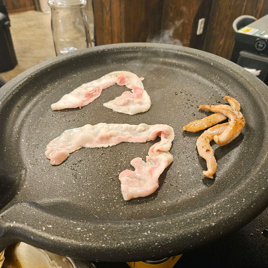 불판 위에 올려진 돼지 껍데기가 맛있게 익어가는 모습