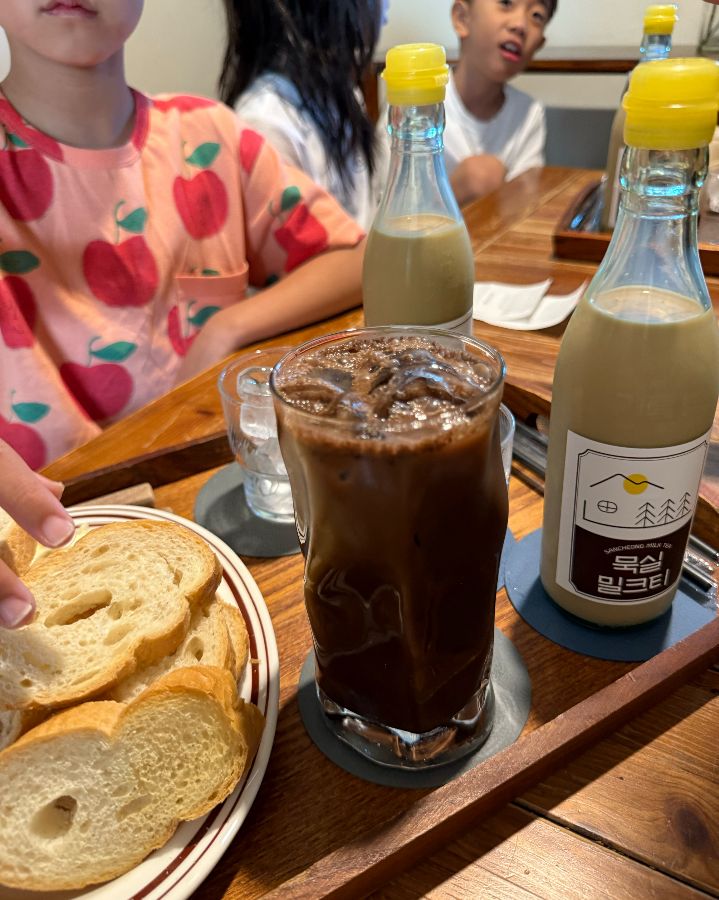 묵실기름병밀크티, 아이스 초코, 카이막 바게트가 놓인 테이블