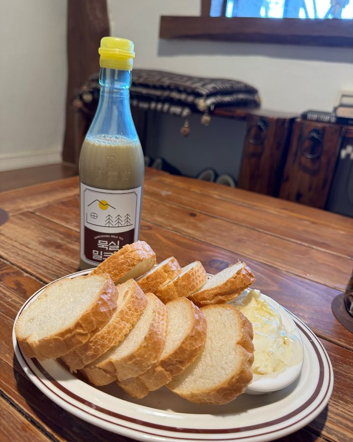 따스한 햇살 아래 놓인 묵실기름병밀크티와 카이막 바게트