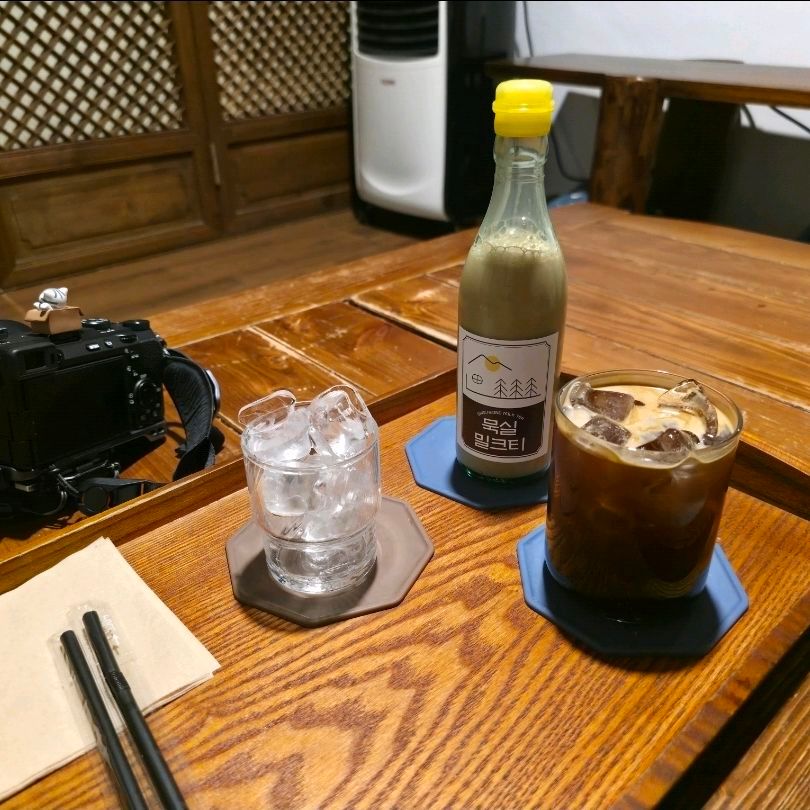 쟁반 위에 정갈하게 놓인 묵실기름병밀크티와 아이스 아메리카노