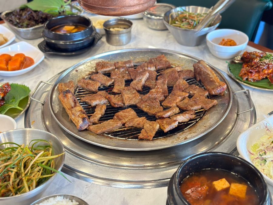 다양한 곁들임 음식과 숯불 돼지 왕갈비가 함께 차려진 풍성한 한 상 차림