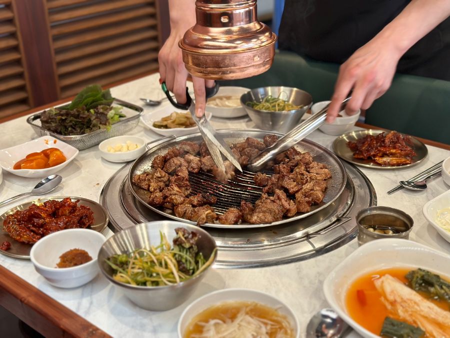 직원이 숯불 위에서 돼지 왕갈비를 능숙하게 구워주는 모습