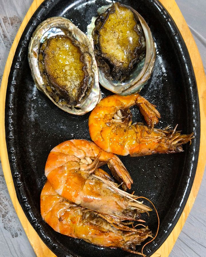 뜨거운 철판 위에서 지글거리는 전복과 새우 버터구이