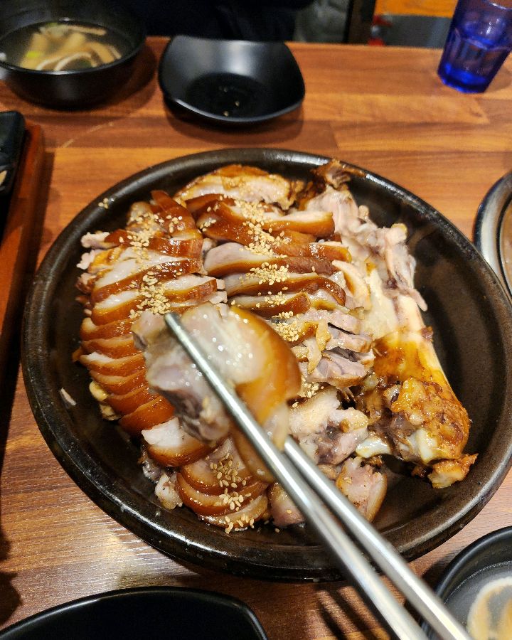 젓가락으로 족발 한 점을 들어 올리는 모습, 쫀득함이 사진에서도 느껴진다.