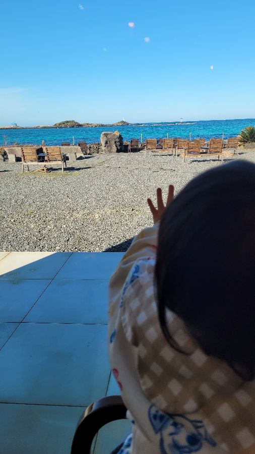 아이가 창밖의 바다를 바라보는 모습