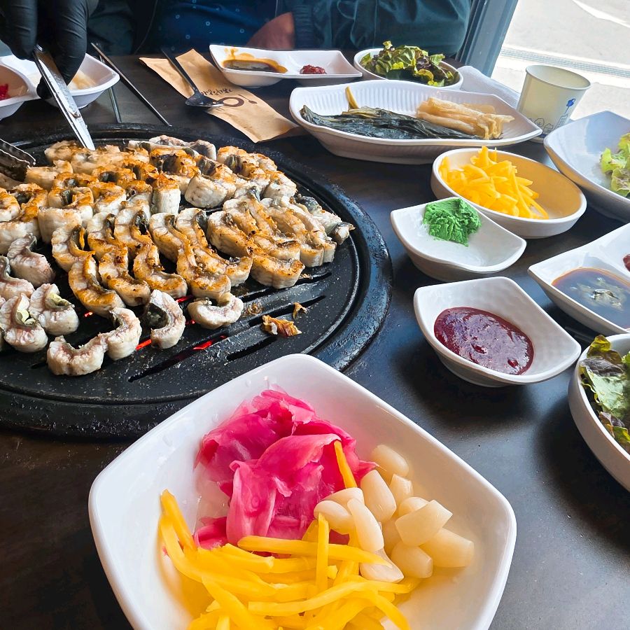 다채로운 밑반찬과 숯불 위에 올려진 장어