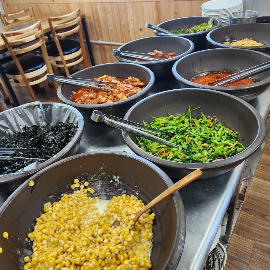 다양한 종류의 신선한 반찬들이 먹음직스럽게 담겨있는 모습