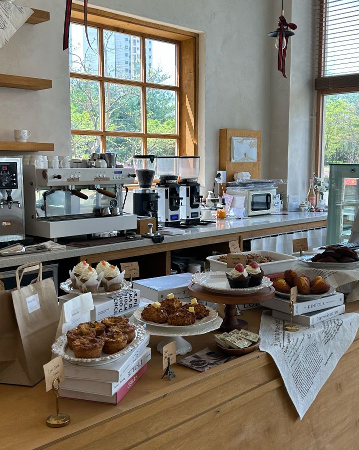 다양한 디저트와 커피 머신이 놓인 브라운 테이블의 카운터 전경