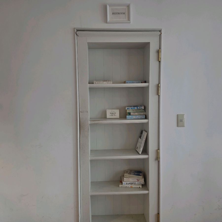 책장처럼 위장된 화장실 문, 위플랜트위커피의 위트 있는 공간 디자인을 엿볼 수 있습니다.