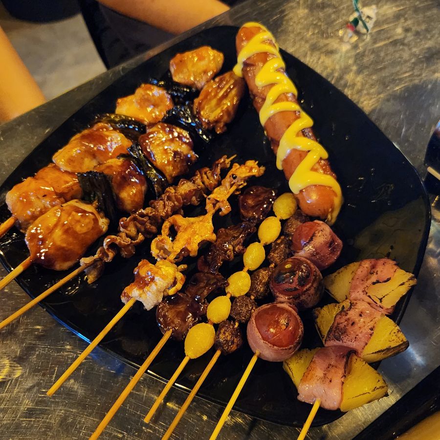 다양한 종류의 꼬치들이 먹음직스럽게 담겨 있는 모습