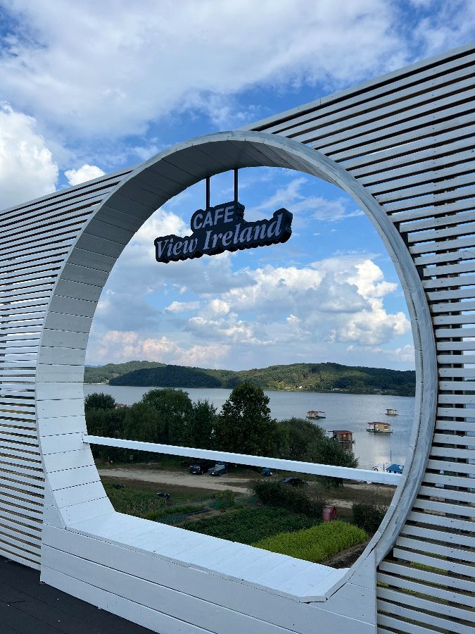 뭉게구름이 드리운 하늘과 잔잔한 호수가 어우러진 아름다운 풍경을 담은 예당 뷰아일랜드의 모습