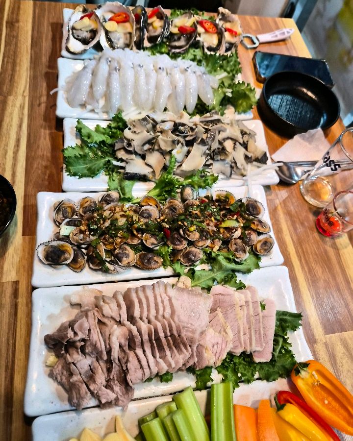 싱싱한 굴, 쫄깃한 소라, 숙성 흰살 생선회가 담긴 해산물 모둠