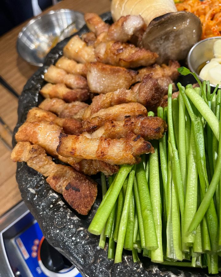 노릇하게 구워진 삼겹살과 싱싱한 미나리의 조화