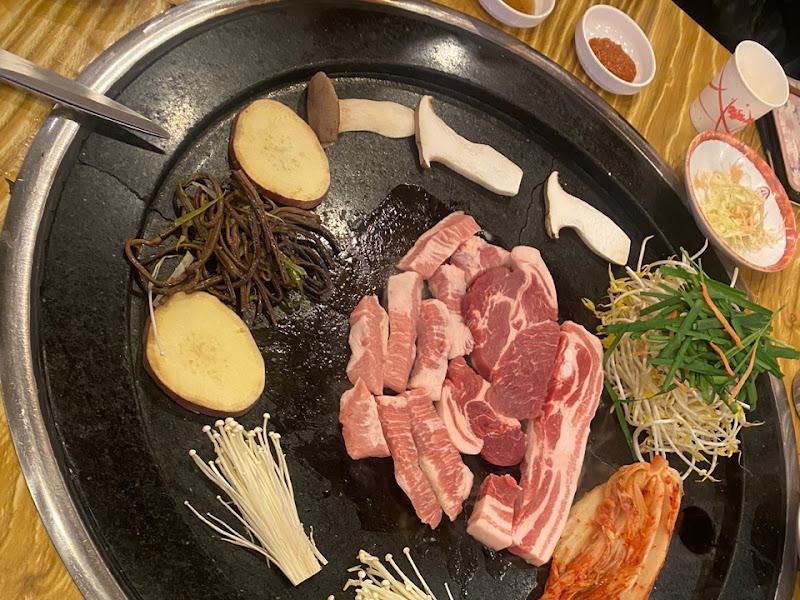 철판 위에 다양한 재료들이 푸짐하게 올려져 있는 모습