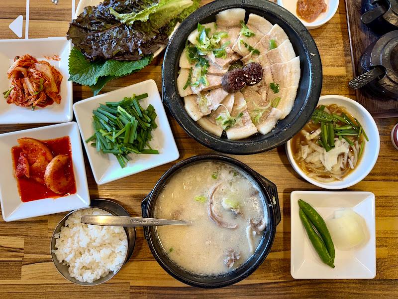 돼지국밥과 수육, 다양한 반찬이 차려진 테이블