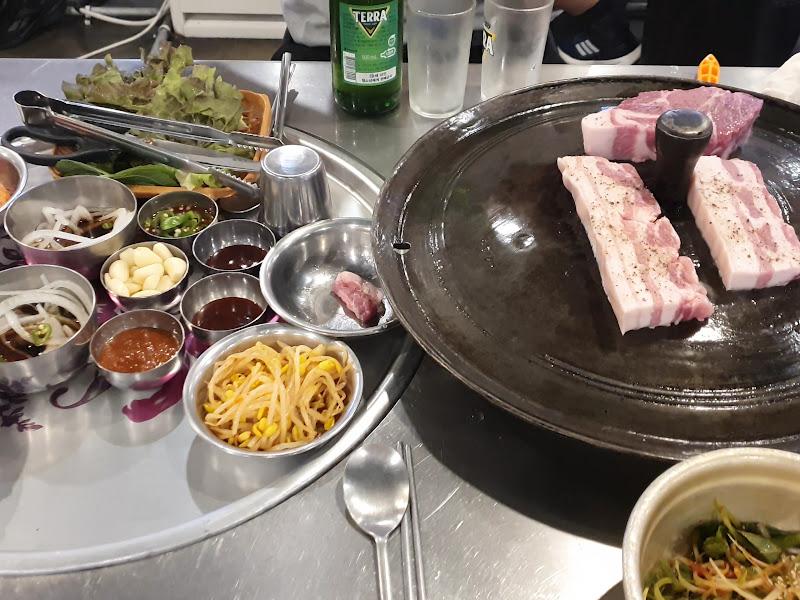 불판 위에 올려진 두툼한 삼겹살과 목살