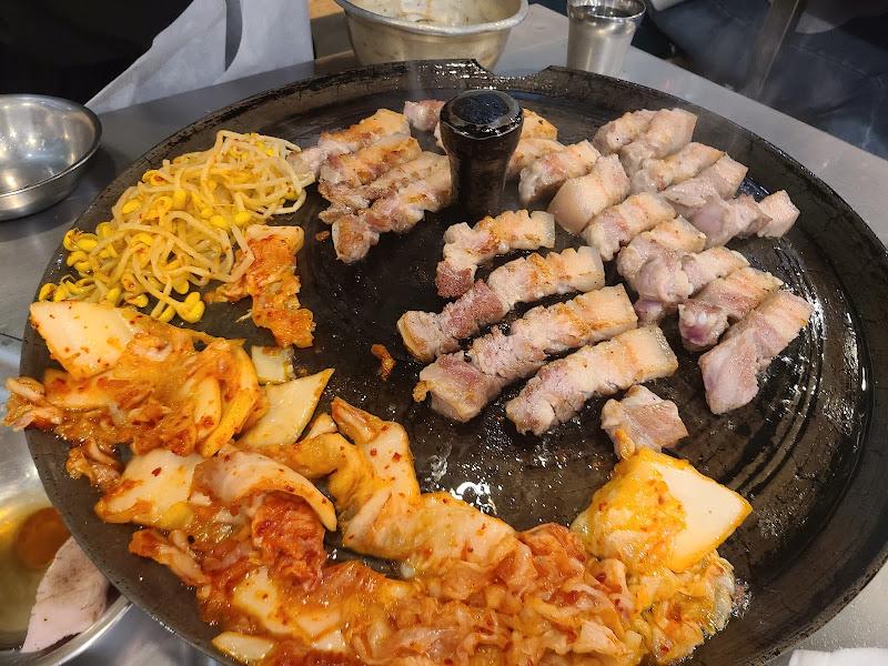 불판 가득 구워진 김치, 콩나물, 스파게티 면과 고기