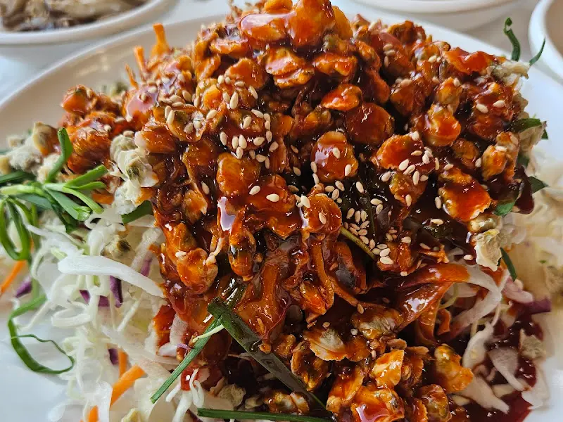 참깨가 듬뿍 뿌려진 재첩회무침의 모습