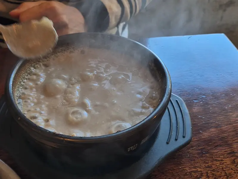 황태해장국을 숟가락으로 뜨는 모습