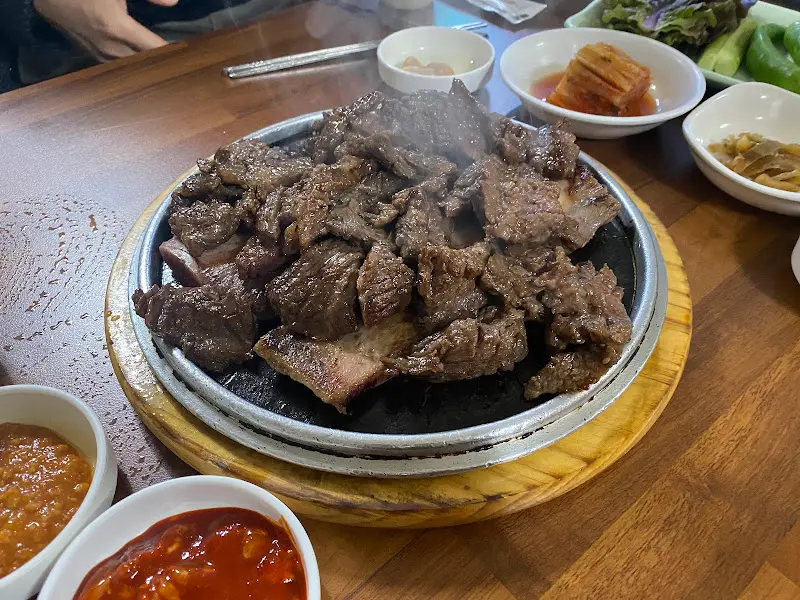 테이블 위에 놓인 따뜻한 돌판 위의 고기